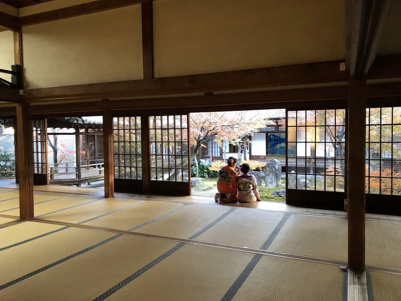Temple hall in Japan opening onto an autumn garden